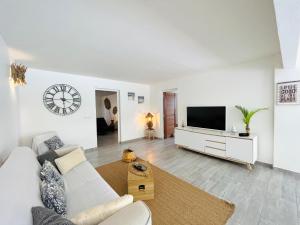 ein Wohnzimmer mit einem weißen Sofa und einem TV in der Unterkunft Résidence Ti Gwapabe, proche raisins clairs in Saint-François