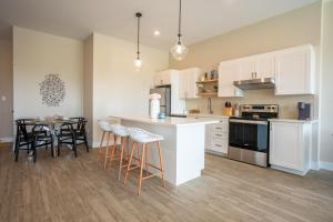 a kitchen with white cabinets and a table and chairs at Brand New and Very Spacious 1 Bedroom Condo! in Chatham