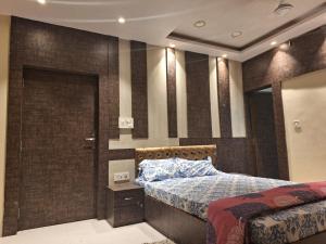 1 dormitorio con cama y pared de ladrillo en Mavenoak Dreams B&B en Calcuta