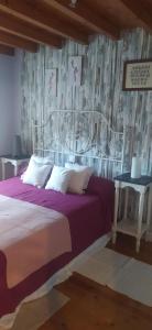 um quarto com uma cama grande e lençóis roxos em VILLA ELSA em Foz