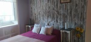 um quarto com uma cama com lençóis roxos e almofadas brancas em VILLA ELSA em Foz