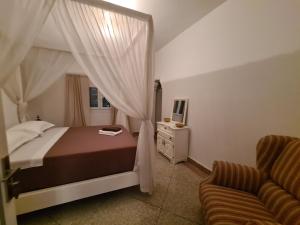 a bedroom with a bed and a couch in it at La Maison des Vagues in Sidi Kaouki