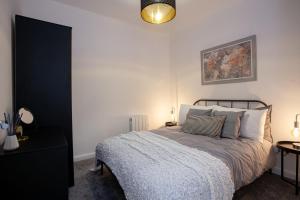 Modern 2 Bedroom Apartment in Bolton في بولتون: غرفة نوم بسرير ودهان على الحائط
