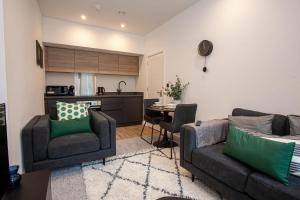 a living room with a couch and chairs and a kitchen at Modern 2 Bedroom Apartment in Bolton in Bolton