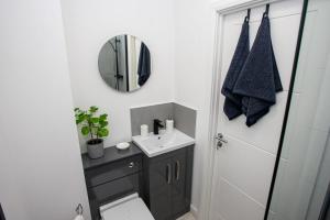 Modern 2 Bedroom Apartment in Bolton في بولتون: حمام مع مرحاض ومغسلة ومرآة