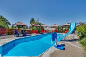a swimming pool with a blue water slide at Yakima Home Rental Seasonal Outdoor Pool, Hot Tub in Yakima