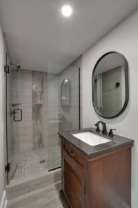 a bathroom with a sink and a shower with a mirror at Oak Luxury Treehouse near Lake Guntersville in Scottsboro