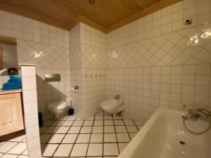 biała łazienka z wanną i toaletą w obiekcie La Casa Nostra in Asker, only 17 minutes to Oslo w mieście Asker