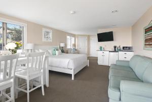 1 dormitorio con cama, mesa y sofá en Chatham Tides en South Chatham