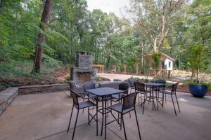 a patio with tables and chairs and a fireplace at 6 Pine Luxury Treehouse near Lake Guntersville in Scottsboro