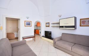 Una sala de estar con un sofá y un televisor. en Casa Tosally, en Ostuni