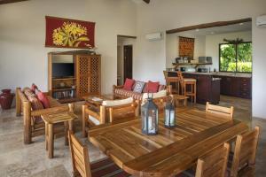 sala de estar con mesa de madera y sillas en Punta Islita Villas Luxury Destination, en Islita