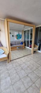 une pièce avec le reflet d'un canapé dans un miroir dans l'établissement 2 pièces vue panoramique sur mer et baie de Cannes, à Théoule-sur-Mer 17 autres photos