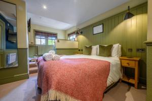 - une chambre avec un grand lit et une couverture rouge dans l'établissement The Horse and Farrier Inn and The Salutation Inn Threlkeld Keswick, à Threlkeld