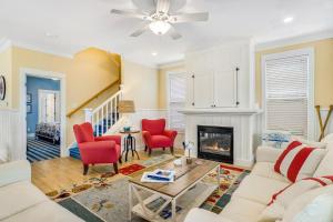 a living room with a white couch and red chairs at Olivia's Rose in Lincoln City