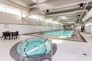 a large swimming pool in a building with a table at Heart of Downtown 1 bd - Pool, Gym, Parking, Office, AC in Vancouver