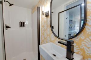 baño con lavabo y espejo en la pared en 15 Daisy Tiny Cottage Near Lake Guntersville, en Scottsboro