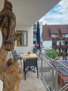 balkon ze stołem, parasolem i budynkiem w obiekcie Bodensee Sunshine Zimmer & Apts. w mieście Uhldingen-Mühlhofen