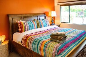 a bedroom with a bed with a colorful blanket and a window at Desert Mermaid in Sedona in Sedona