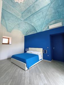 Casale Forno Vecchio في ترامونتي: غرفة زرقاء مع سرير بسقف ازرق