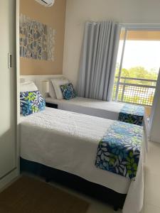 two beds in a bedroom with a balcony at Flat Granja Viana - espaço e conforto in Cotia +37 photos