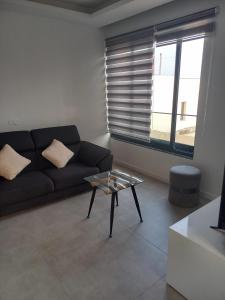 Una sala de estar con un sofá y una mesa de cristal. en La Calicia - Residência Marina, en Praia