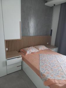 Un dormitorio pequeño con una cama y un espejo. en La Calicia - Residência Marina, en Praia