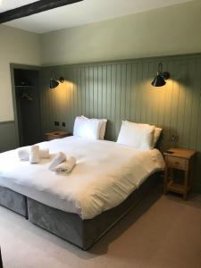 um quarto com uma cama grande com duas toalhas em The Horse and Farrier Inn and The Salutation Inn Threlkeld Keswick em Threlkeld