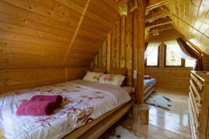 Dormitorio de una cabaña de madera con cama en Pura Vida Forest Home en Poiana Horea