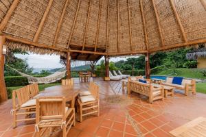 un pabellón con mesa, sillas y hamaca en Punta Islita Villas Luxury Destination, en Islita