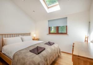 a bedroom with a bed with two towels on it at Pelican Barn in East Carleton