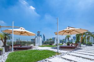 a patio with two umbrellas and benches and grass at 2floors luxury apartment condesa in Mexico City
