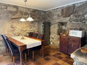 a kitchen with a wooden table and a microwave at Villa Parra in Santa Cristina de Cobres