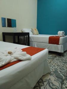 Habitación de hotel con 2 camas y toallas. en El Rancho De Don Moncho Hostel 