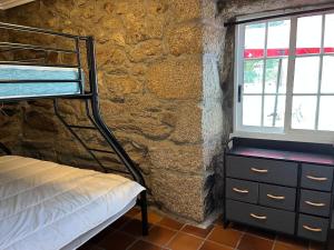 a bedroom with a bed and a stone wall at Villa Parra in Santa Cristina de Cobres