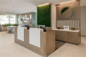 a lobby with a reception desk with a green wall at Element San Jose Milpitas in Milpitas