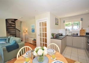 a kitchen and living room with a table and chairs at Heylyn in Little Petherick