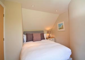 a small bedroom with a white bed in a room at Heylyn in Little Petherick