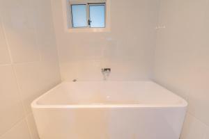een witte wastafel in een witte badkamer met een raam bij Eden Motel in Eden