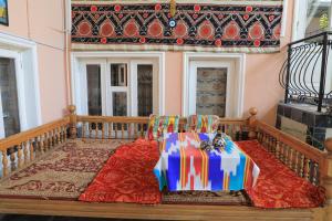 a couch with a gift on it on a balcony at Nursultan Grand Guest House in Samarkand