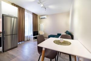 a kitchen and living room with a white table and chairs at City center 1-Bedroom Apartment in Plovdiv