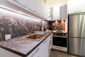 a kitchen with a sink and a stainless steel refrigerator at City center 1-Bedroom Apartment in Plovdiv