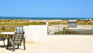 a patio with a table and chairs and the beach at Appartements neufs et modernes entre ter et mer in Soliman