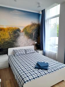 1 dormitorio con 1 cama y una pintura de playa en Pokoje przy Plaży Sopot, en Sopot