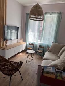 sala de estar con sofá y TV en Charmante maison de ville avec jardin - MIAMOR, en Castres