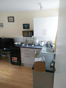 a small kitchen with a sink and a microwave at Haven Apartments in Whitehaven