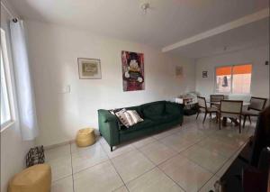 瓜拉圖巴的住宿－Residencial Passos，客厅配有绿色沙发和桌子