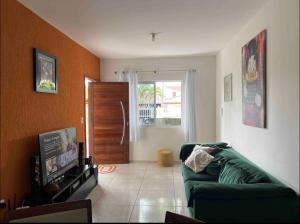 a living room with a green couch and a door at Residencial Passos in Guaratuba