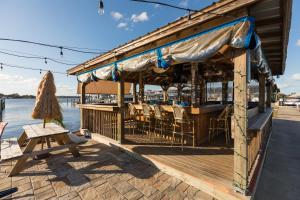 ein Restaurant auf einer Anlegestelle mit einem Tisch und Stühlen in der Unterkunft New Floating Luxury: Unique Houseboat Retreat in Fleming Island