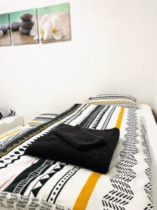 a bed with black and white sheets on it at Apartment MILA in Sankt Peter